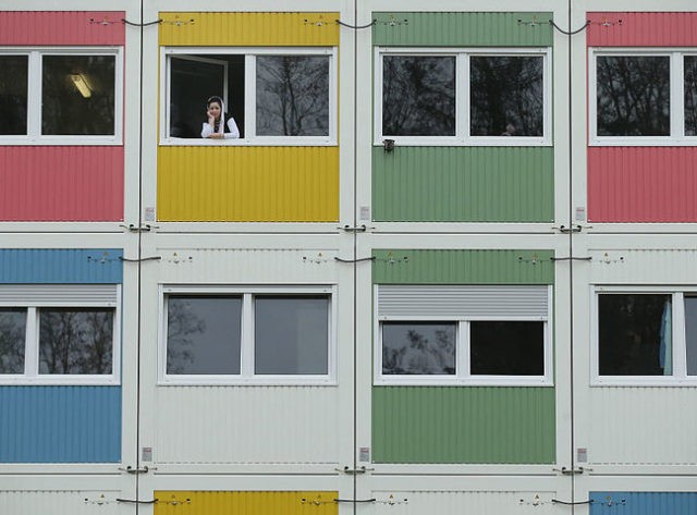 BERLIN, GERMANY - APRIL 14: A resident looks from her window at the container settlement
