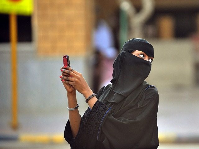 Saudi women take pictures with their mobile phones after the end of a prayer performed on