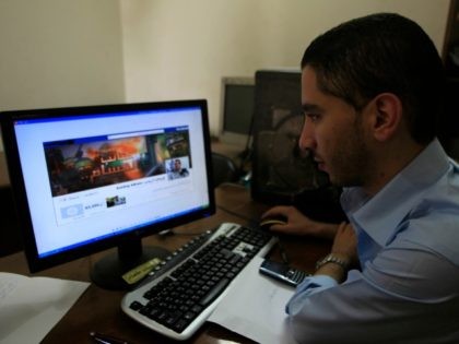 A Palestinian man looks at the Facebook page of Avichay Adraee, the spokesman of the Israe