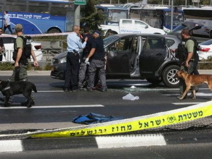 Israeli forensic policemen collect evidence from a car belonging to a victim following a shooting attack near the Israeli police headquarters in mainly Palestinian east Jerusalem on October 9, 2016. A shooting attack in Jerusalem left at least three people wounded, including two seriously, with the assailant killed by police, …