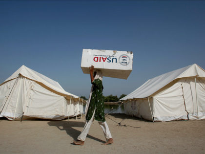 A woman, who has been displaced by floods, uses a USAID box to move her belongings while taking refuge on an embankment at Chandan Mori village in Dadu, some 320 km (199 miles) north of Karachi October 10, 2010. REUTERS/Akhtar Soomro