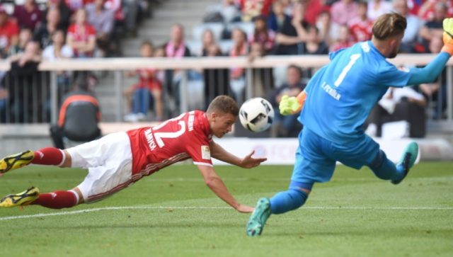 Bayern Munich's midfielder Joshua Kimmich (L) heads the first goal for Munich against Colo
