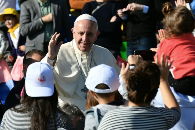 Pope Francis (centre) greets worshippers as he arrives for a Holy Mass at the stadium in T