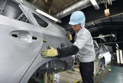 A worker makes surface inspections before the painting process on the production line at Toyota's Tsutsumi plant in Japan's Aichi prefecture