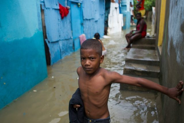 A boy is pictured in the flooded neighbourhood of La Puya, in Santo Domingo on October 4,
