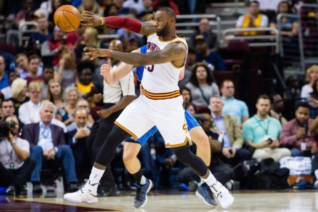 LeBron James of the Cleveland Cavaliers passes while under pressure from Jeff Green of the
