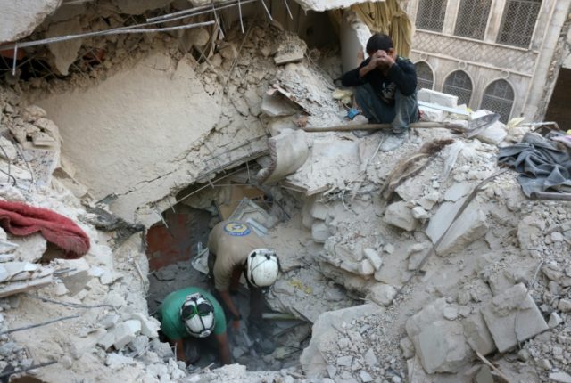 Syrian civil defence volunteers search for victims amid the rubble following government ai