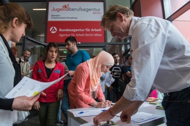 Participants register for a professional training fair aimed at refugees, at an employment
