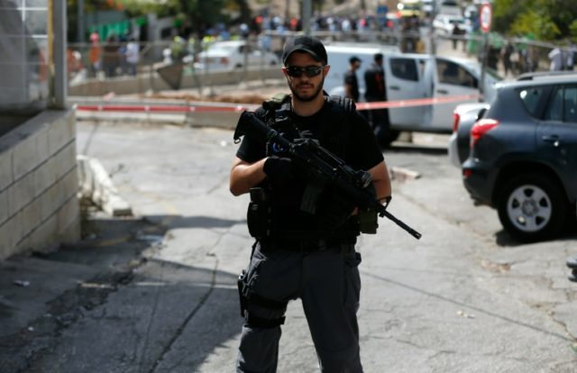 A member of the Israeli security forces guards the site of a shooting attack near the line