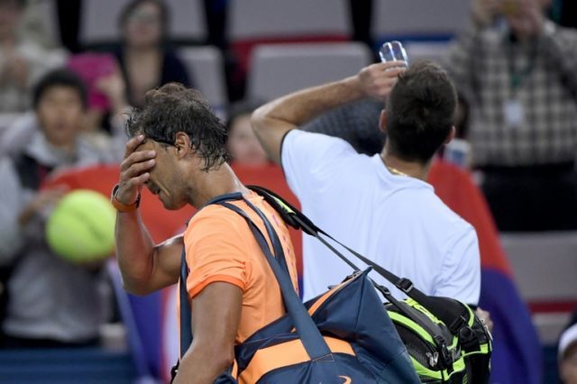 Rafael Nadal of Spain (left) walks off court after defeat by Serbia's Viktor Troicki at th