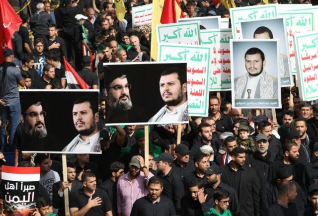Supporters of Lebanon's Shiite movement Hezbollah and a Yemeni delegation carry posters of