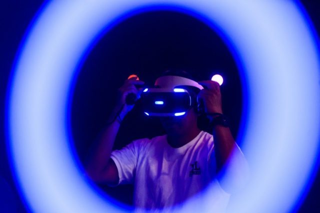 A man plays a Sony Playstation virtual reality game at the annual Ani-Com show in Hong Kon