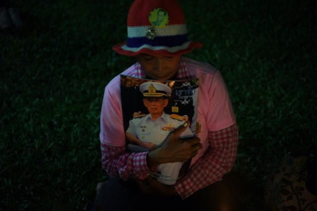 A woman carries an image of Thailand's King Bhumibol Adulyadej after his death at Siriraj