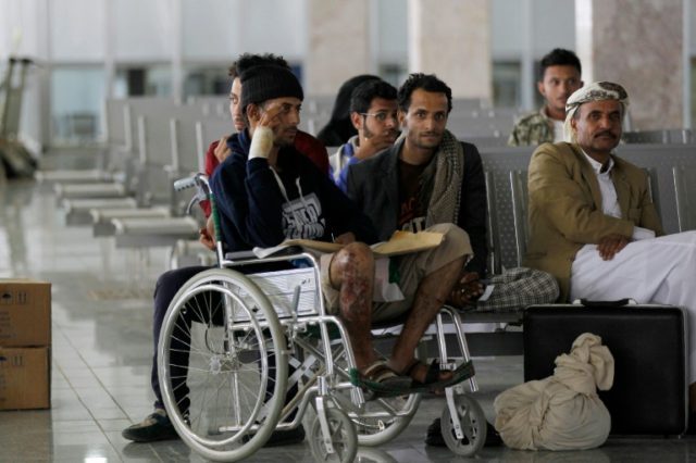 Wounded Yemeni men sit in the airport in Sanaa on October 15, 2016, as they wait for an Om