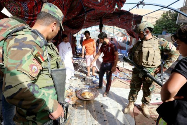 Iraqis inspect the damage at the site of a suicide bombing that targeted Shiite Muslims in