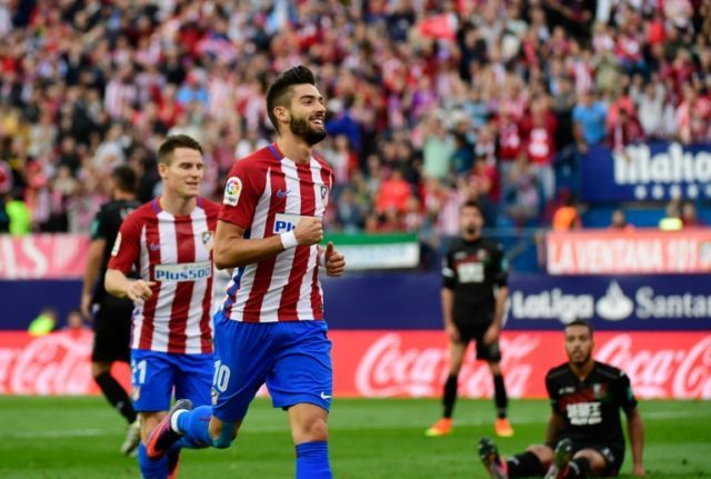 Yannick Carrasco scored a hat-trick in a 7-1 rout for leaders Atletico Madrid over Granada
