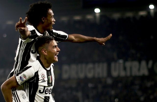 Juventus' forward Paulo Dybala (down) celebrates with Juan Cuadrado after scoring against