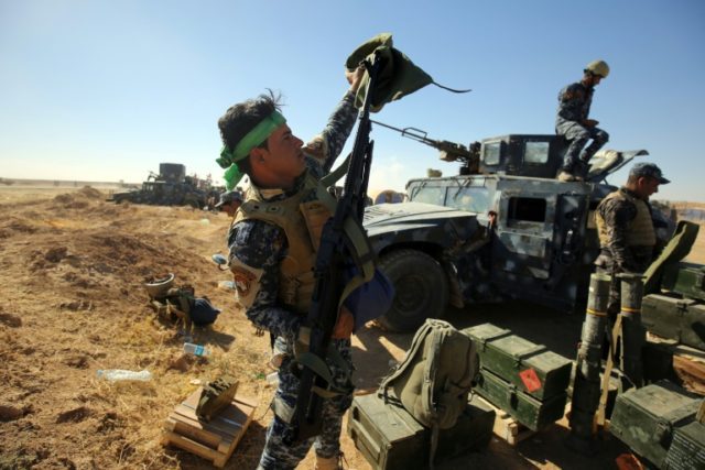 An Iraqi policeman inspects his weapon at the Qayyarah military base, about 60 kilometres