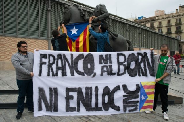 Protestors hang a Catalan Pro-independence flag on a headless sculpture of Francisco Franc