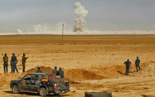 Smoke billows as Iraqi forces hold a position on October 17, 2016 in the area of al-Shurah
