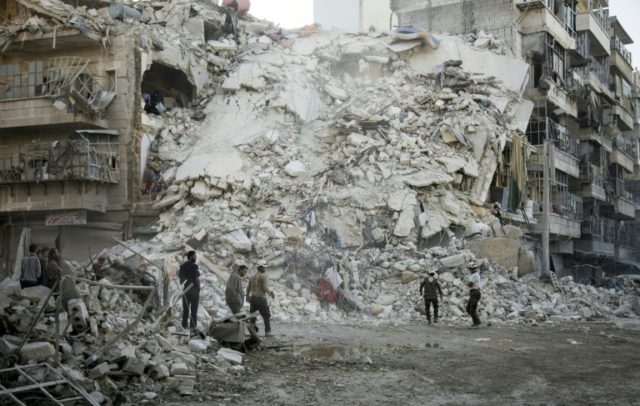 Members of the White Helmets search for victims amid the rubble of a destroyed building fo