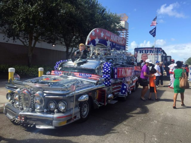 Supporters of US Republican presidential nominee Donald Trump gather next to a vehicle bef