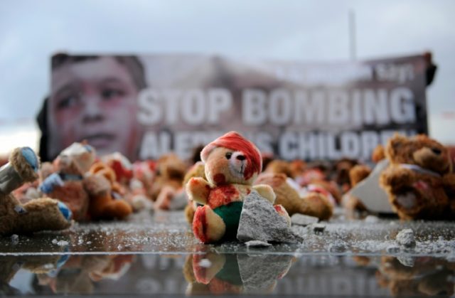 Colour-smeared teddy bears are laid by campaign group Avaaz in Berlin to protest the bombi