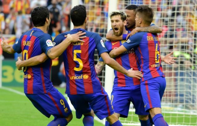 Barcelona's Argentinian forward Lionel Messi (C) celebrates with teammates after scoring d