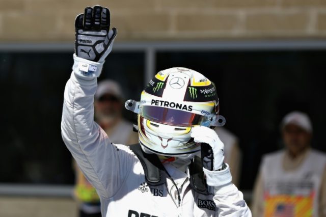 Lewis Hamilton of Great Britain and Mercedes GP waves to the crowd after qualifying in pol