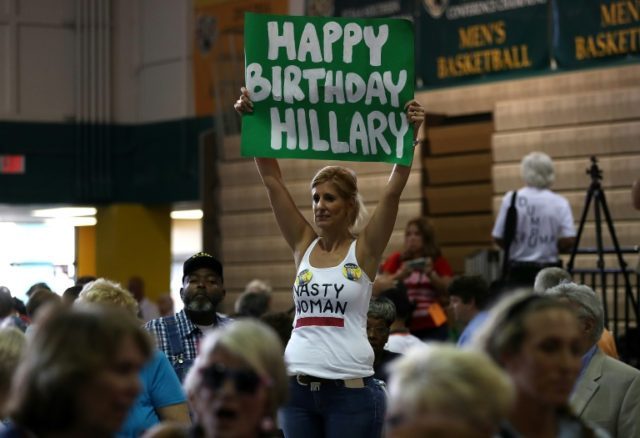 A supporter holds a sign reading, "Happy Birthday Hillary" during a campaign rally at Palm