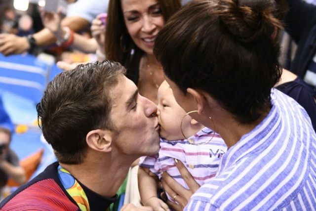 USA's Michael Phelps (L) kisses his son Boomer, held by Nicole Johnson at the Rio Olympics