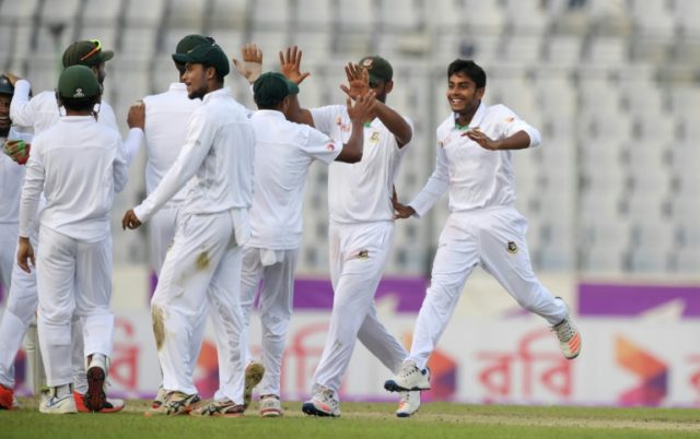 Bangladesh spinner Mehedi Hasan (R) celebrates with teammates after the wicket of England'