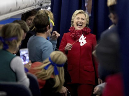 Democratic presidential candidate Hillary Clinton laughs with staff aboard her campaign plane at Cincinnati/Northern Kentucky International Airport in Hebron, Ky., Monday, Oct. 31, 2016, before traveling to Westchester, N.Y. on Halloween. (AP Photo/Andrew Harnik)