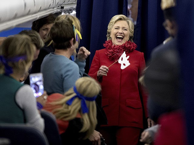 Democratic presidential candidate Hillary Clinton laughs with staff aboard her campaign pl