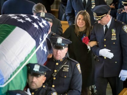 Lisa Tuozzolo, wife of the late Sgt. Paul Tuozzolo is escorted by a high ranking New York