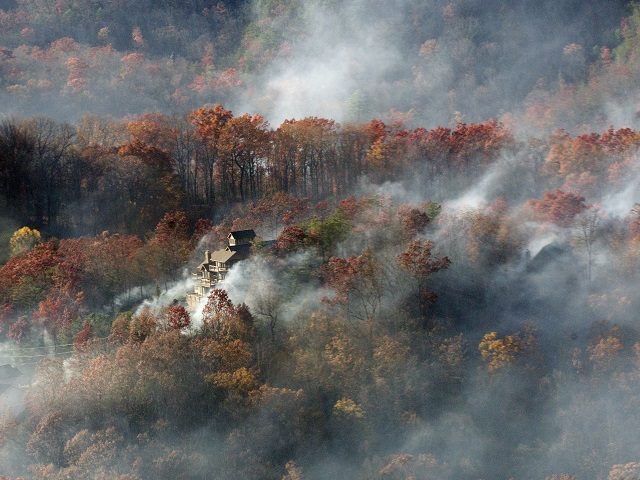 Smoke surrounds a home as seen from aboard a National Guard helicopter near Gatlinburg, Te
