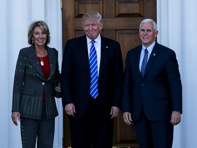 United States President-elect Donald Trump (C) and Vice President-elect Mike Pence (R) pose with Betsy DeVos at the clubhouse of Trump International Golf Club, November 19, 2016 in Bedminster Township, New Jersey.