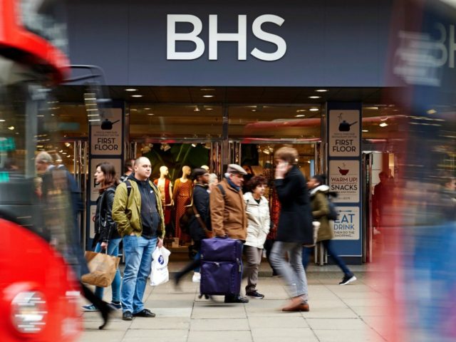 Pedestrians and London buses pass the entrance to a BHS …