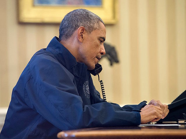 WASHINGTON, DC - OCTOBER 12: U.S. President Barack Obama speaks on the phone with Health and Human Services Secretary Sylvia Burwell for an update on the response to the Ebola diagnosis in Dallas, in the Oval Office of the White House October 12 =, 2014 in Washington DC. A nurse …