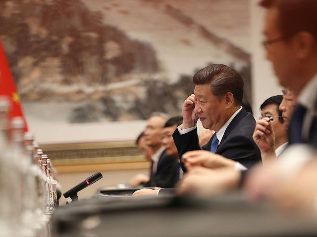 Chinese President Xi Jinping (C) adjusts his ear phones during his meeting with US Preside