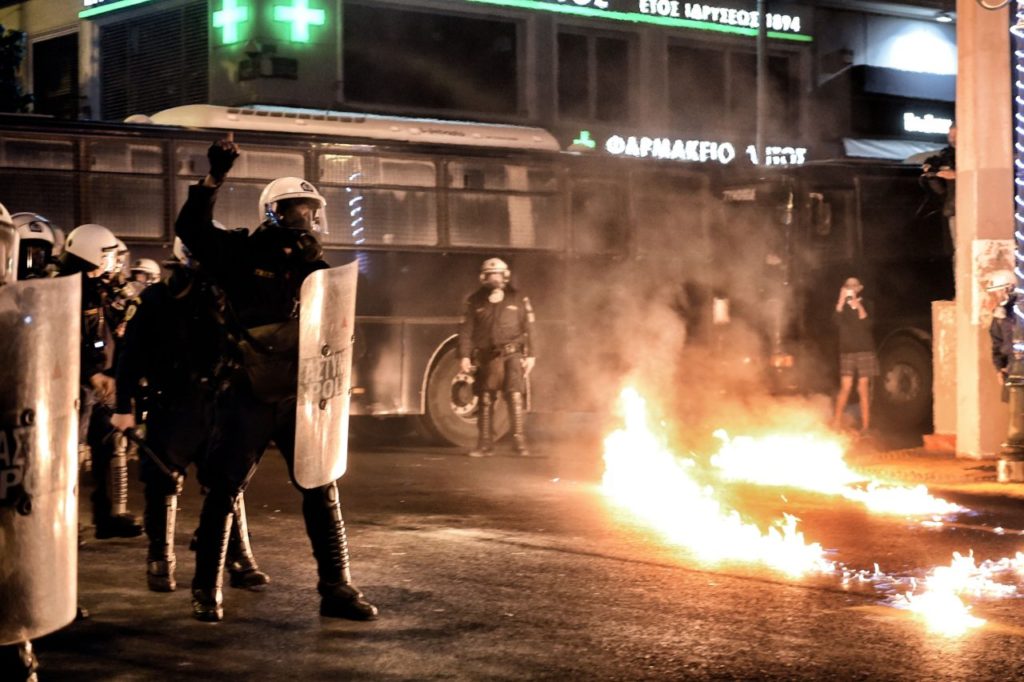 Fire burns on the asphalt next to Greek riot police as they clash with demonstrators during a protest against the visit of the US president in Athens on November 15, 2016. US President Barack Obama is in Greece on a two-day official visit. / AFP / ARIS MESSINIS (Photo credit should read ARIS MESSINIS/AFP/Getty Images)