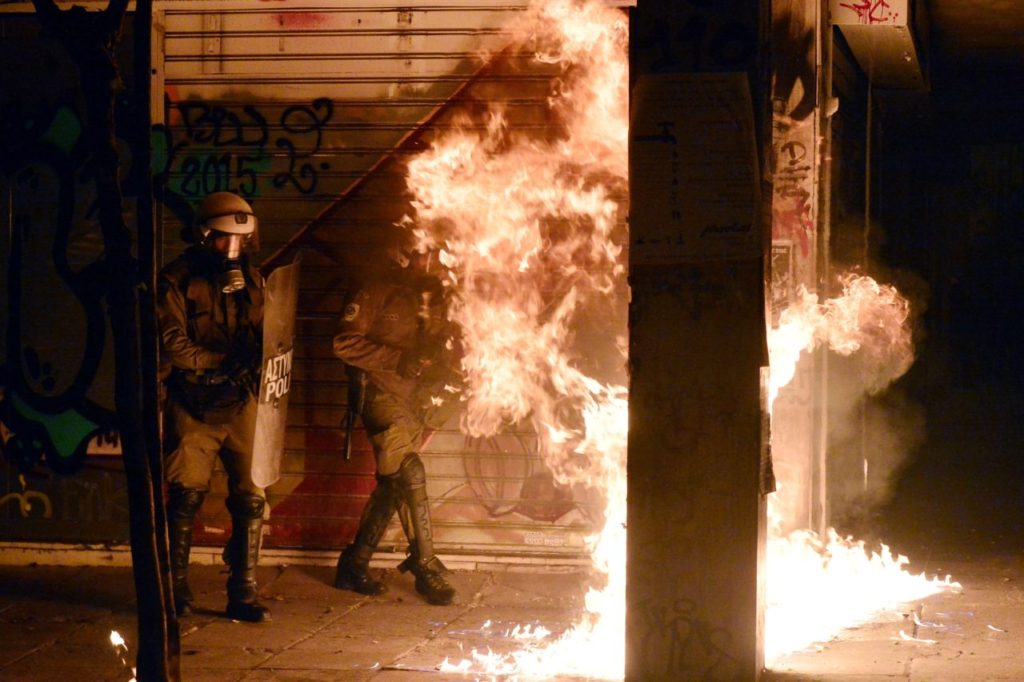 Fire from a molotov cocktail burns near Greek riot police during clashes around the Polytechnic school, following a protest against the visit of the US president in Athens on November 15, 2016. US President Barack Obama is in Greece on a two-day official visit. / AFP / LOUISA GOULIAMAKI (Photo credit should read LOUISA GOULIAMAKI/AFP/Getty Images)