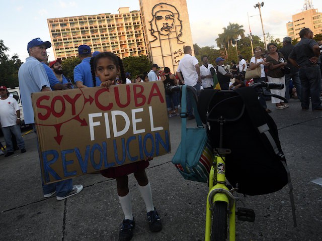 A girl holds a sign reading "I am Cuba, Fidel, Revolution" as Cubans gather at Revolution Square to pay homage to late Cuban revolutionary leader Fidel Castro, in Havana, on November 29, 2016. A titan of the 20th century who beat the odds to endure into the 21st, Castro died late Friday after surviving 11 US administrations and hundreds of assassination attempts. No cause of death was given. Castro's ashes will go on a four-day island-wide procession starting Wednesday before being buried in the southeastern city of Santiago de Cuba on December 4. / AFP / RODRIGO ARANGUA (Photo credit should read RODRIGO ARANGUA/AFP/Getty Images)