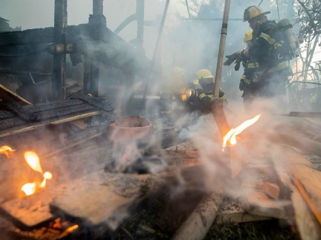 Israeli firefighters help extinguish a fire in the northern Israeli port city of Haifa on
