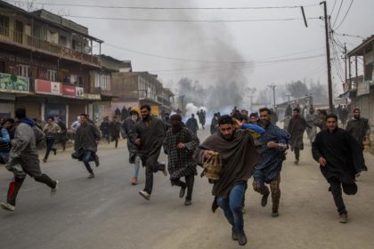 Kashmiri villagers run for cover from tear gas shells and pellets fired at them by Indian