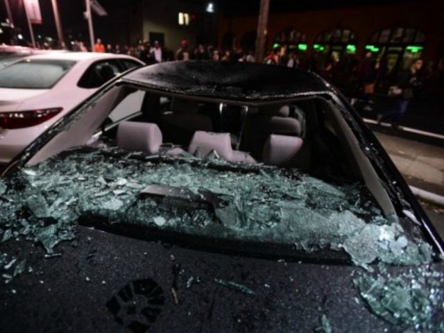 Numerous cars at a Toyota dealership were smashed as protesters marched through the street