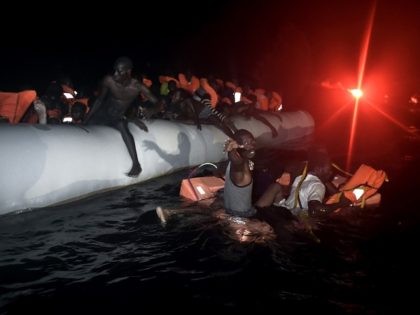 TOPSHOT - Migrants and refugees wait to be rescued from their sinking rubber boat some eight nautical miles off Libya's Mediterranean coastline on October 12, 2016. A growing number of people are attempting the treacherous sea journey from Libya or Egypt, after the closure of the Balkan migrant trail route …
