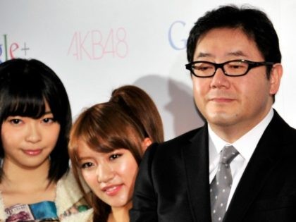 Google vice president Bradley Horowitz (C) smiles with Japanese all-girl pop group AKB48 m