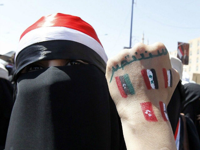 (An anti-government protester displays paintings on her hand of other countries involved i