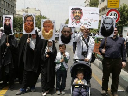 Iranian protesters hold portraits of (from L to R) Saudi King Salman, US Democrat presidential candidate Hillary Clinton, US Republican presidential candidate Donald Trump, US President Barack Obama, Bahraini King Hamad and Israeli Prime Minister Benjamin Netanyahu, most adorned with jihadist-style beards and a slogan reading 'is Daeishian' (Daesh is …
